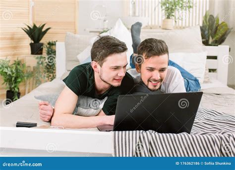 Casal Gay Feliz Deitado Na Cama Laptop Em Casa Foto De Stock Imagem De Relacionamento