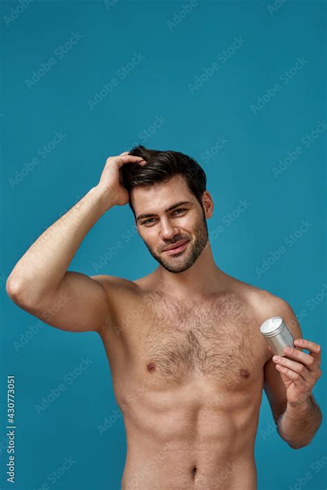 Portrait Of Sexy Brunette Guy With Bristle Holding Silver Jar With Gel