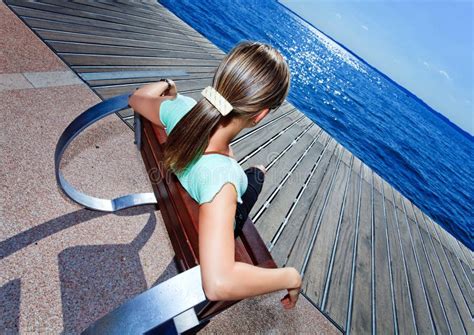 Het Meisje Van De Blonde Het Ontspannen Als Voorzitter Bij Kust Stock