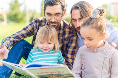 Casal Gay Seus Filhos Lendo Um Livro Foto De Stock Imagem De Feliz Paternidade