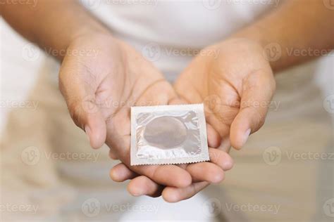 Condom Ready To Use In Male Hand Give Condom Safe Sex Concept On The Bed Prevent Infection And