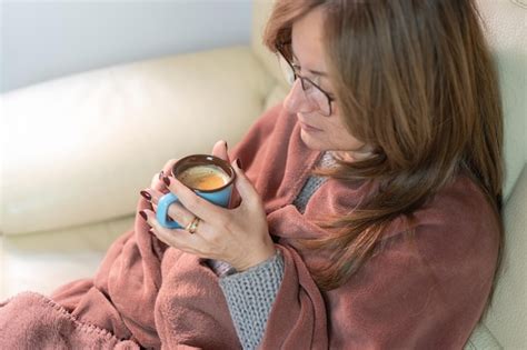 Premium Photo Woman Warming Her Hands With A Hot Cup Of Coffee While Enjoying The Warmth Of