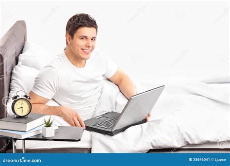 Man Lying On A Bed And Working On A Laptop Stock Image - Image: 25646041