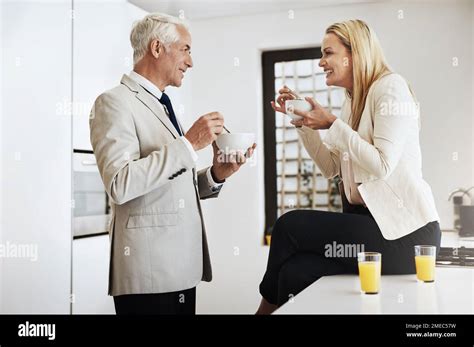 Couples Breakfast Routine A Cheerful Mature Couple Eating Breakfast Cereal Together In The