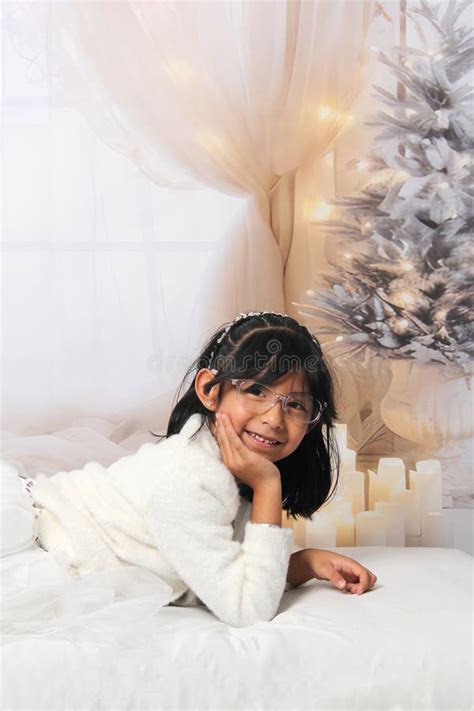 5 Year Old Latina Girl With Eyeglasses Among Decorated Trees Is Excited To Celebrate Christmas