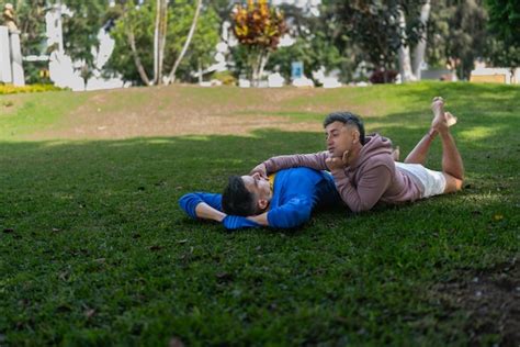 Premium Photo Gay Couple Lying On The Grass In A Park With A Tender Attitude