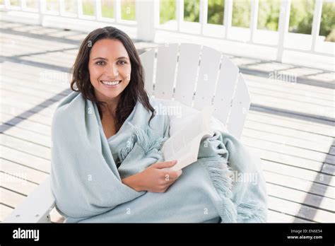 Pretty Brunette Sitting On A Chair And Reading A Book Stock Photo Alamy