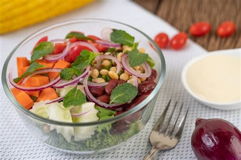 Salada De Frutas E Legumes Em Um Copo De Vidro Fundo Branco Foto