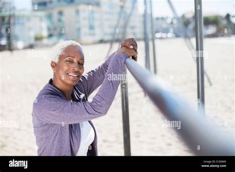 Portrait Of Confident Woman Leaning On Bar At Beach Playground Stock