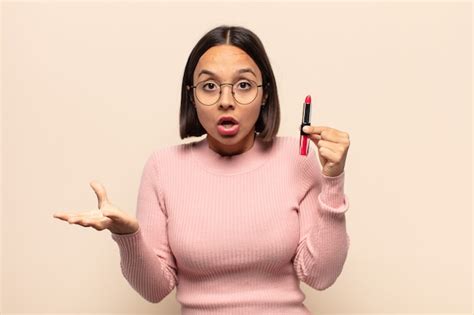 Joven latina que se siente extremadamente conmocionada y sorprendida ansiosa y en pánico con