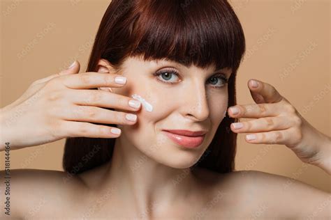 Smiling Caucasian Woman With Red Hair And Healthy Skin Posing With Cream Under Eyes And Naked