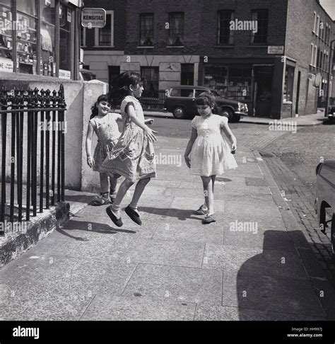 1950s Historical Three Young Girls Playing Together On The Pavement