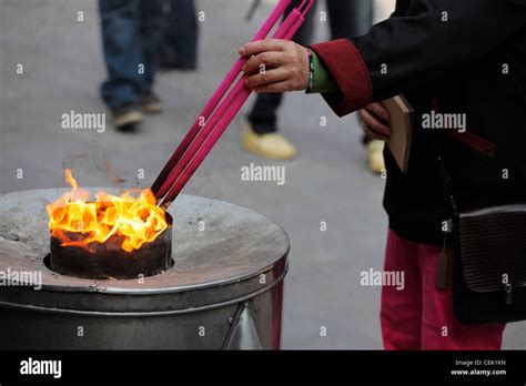 Woman Lighting Large Incense Sticks In Flame China Stock Photo Alamy