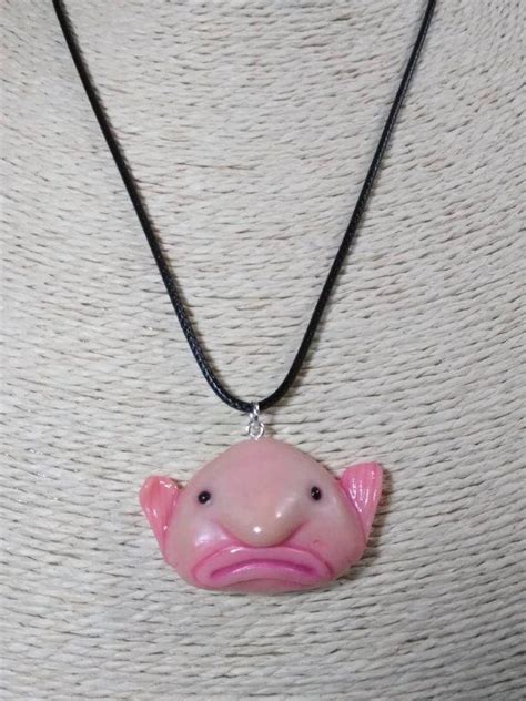 A Woman Wearing A Necklace With A Pink Pig On It