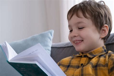 Little Cute Boy Reading A Book And Laughing Stock Photo Image Of