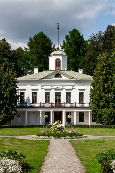 White historic manor house surrounded by lush green trees photo – Free
