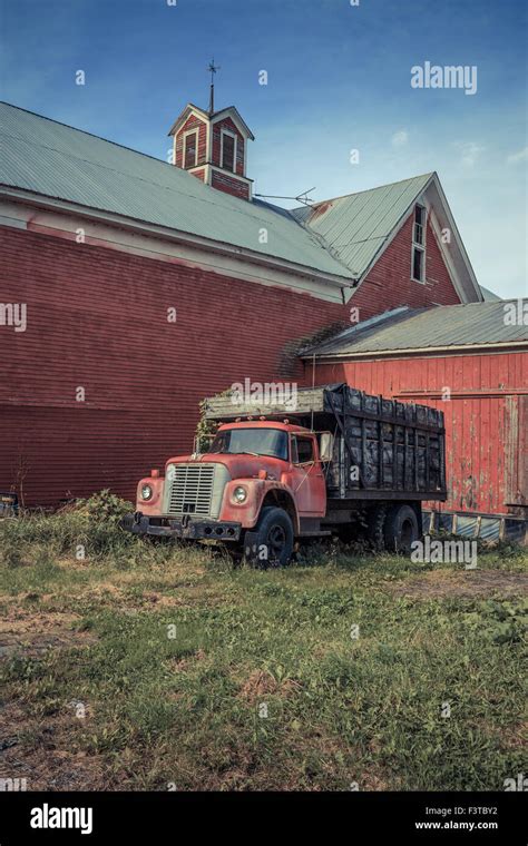 An Old Red Farm Truck In Front Of An Old Red Barn In Vermont Stock