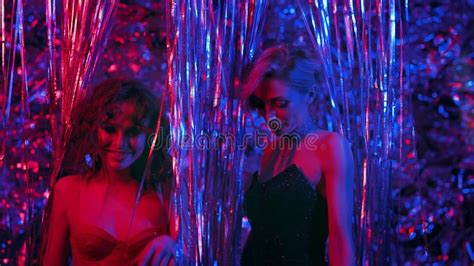 Deux Jeunes Filles Dansant Dans Une Boîte De Nuit Entre Paillettes Blonde Et Brune En Robes Du