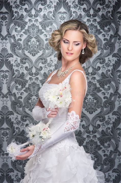 Eine Junge Blonde Braut in Einem Langen Weißen Kleid Aufwirft Stockfoto Bild von mädchen