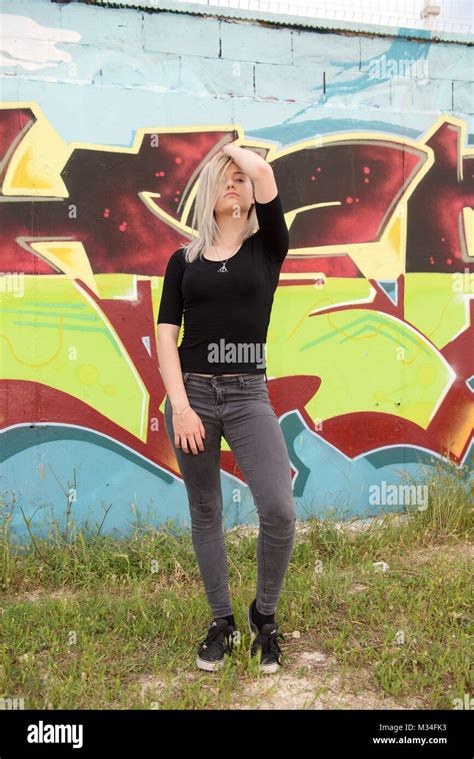 Belle Fille Blonde En Jeans Se Leva D Un Mur De Graffiti Photo Stock Alamy