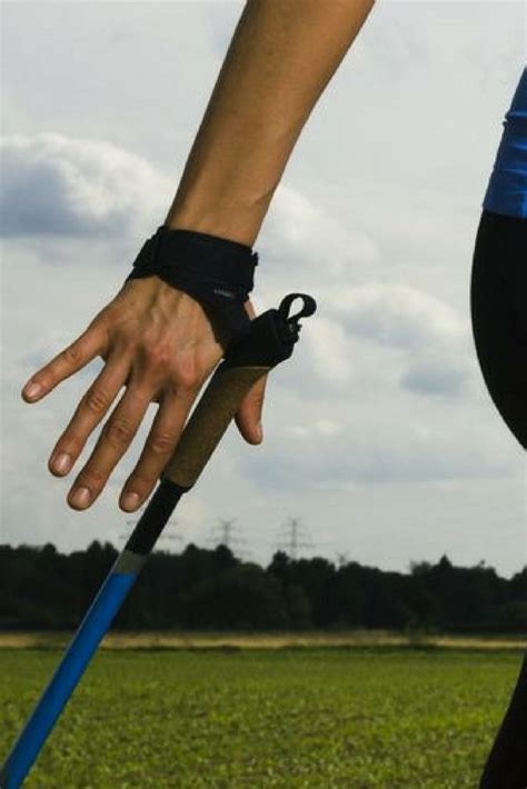 A Person With Their Hand On The Handle Of A Walking Stick In Front Of A