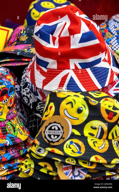 Colourful display of hats with emojis and Union Jack badges on sale, UK