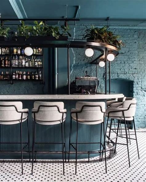 A Bar With Stools And Plants On The Back Wall In A Room That Has Blue