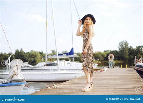 Girls On Background Of Yachts Sailing Boats Smiling Looking At The Camera Beautiful Blonde Is