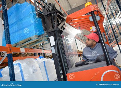 Trabajador De Warehouse Que Conduce La Carretilla Elevadora Imagen De