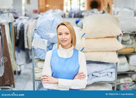 Портрет работника девушки в прачечной склада с чистыми одеждами ...