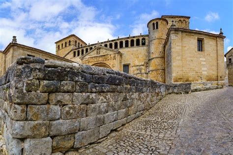 Panorâmica da antiga igreja românica de pedra calçada e céu azul