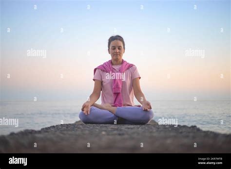 Yoga Woman Meditation In Lotus Position At Pebble Sea Beach Sunset Sky