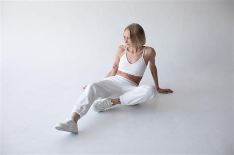 Free Photo Beautiful Blonde Woman In A White Tshirt And Blue Jeans Posing On A White Background