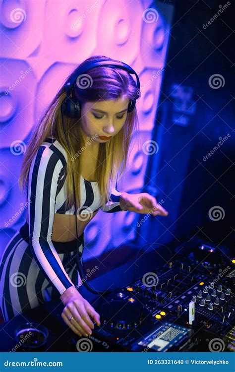 Beautiful Positive Girl DJ Blonde Energetic Plays And Listens To Music In A Nightclub Party At