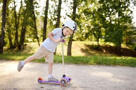 Menino Da Crian A No Capacete De Seguran A Aprendendo A Andar De