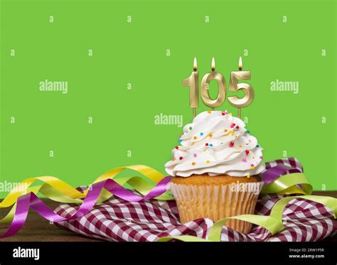 Birthday Cake With Candle Number 105 On Green Background Stock Photo