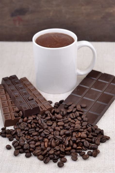 Белая чашка горячего шоколада на кофейных зернах и Backgro шоколада ...