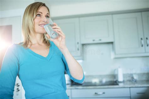 Femme Assez Blonde Buvant Un Verre De L Eau Photo Stock Image Du Cuisine Maison 66977332