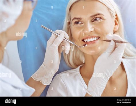 Smiling Blonde Woman Examined By Dentist At Sunny Dental Clinic