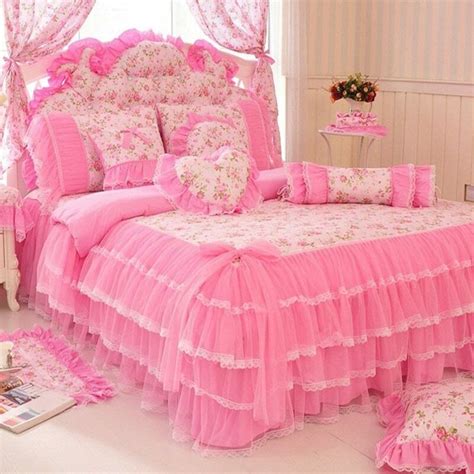 A Bed With Pink Bedspread And Pillows In A Room