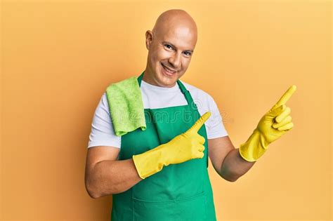 Middle Age Bald Man Wearing Apron Holding Cleaning Gloves Smiling And