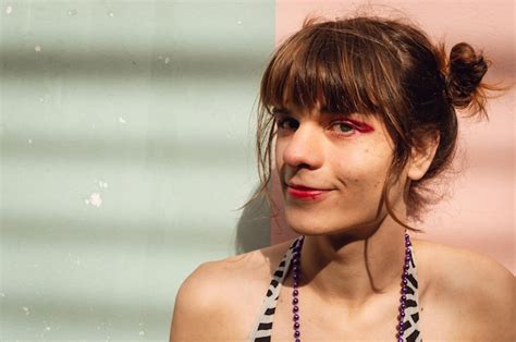 Retrato De Joven Mujer Latina Transg Nero Al Aire Libre Sobre Fondo De Pared Rosa Y Verde Foto