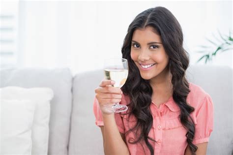 Premium Photo Smiling Cute Brunette Sitting On Couch Holding White Wine Glass