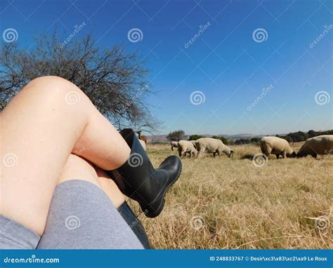 Caucasian Naked Legs Wearing Grey Shorts And Black Boots Legs Up One Foot On Knee Lying In A