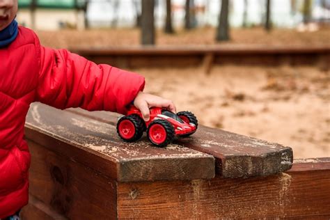 Niño jugando con coche de juguete en el patio de recreo Foto Premium