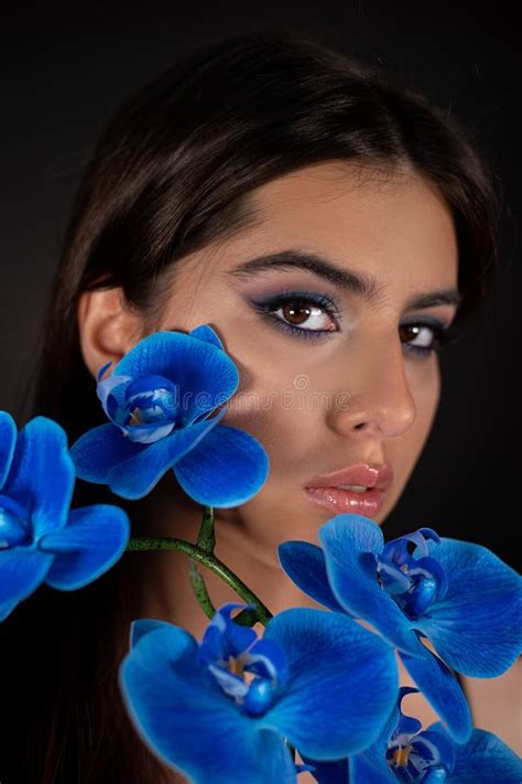 Vertical Eye Catching Charming Seductive Brunette Woman With Blue Evening Make Up And Flower