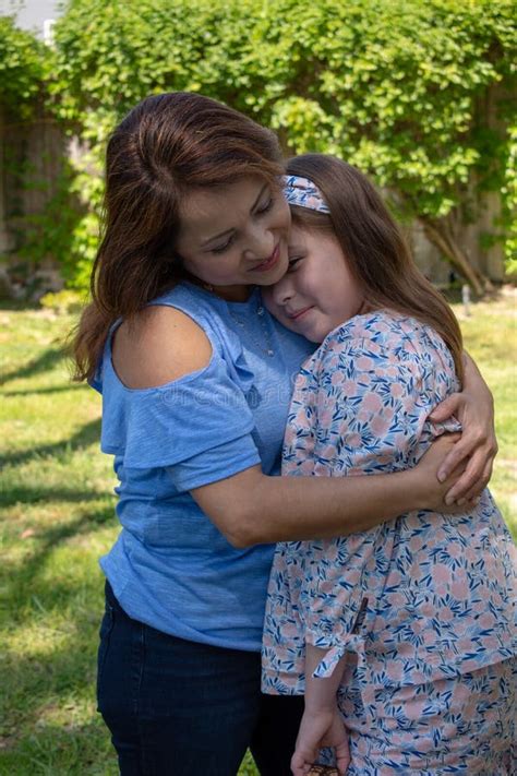 Exterior Sonriente Y De Risa De La Madre Y De La Hija De Latina En Patio Trasero Imagen De