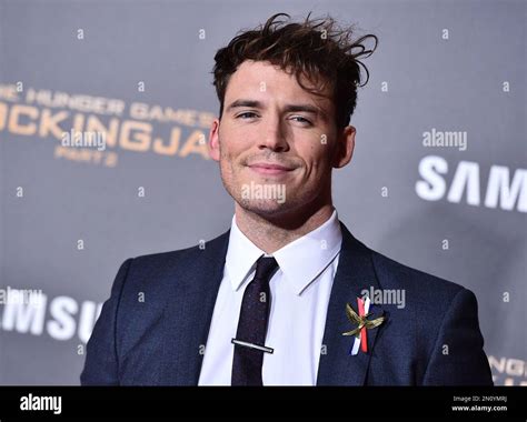 Sam Claflin, wearing a Mockingjay pin with the French tricolor, arrives ...