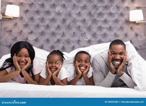 Retrato De La Familia Sonriente Que Miente Junto Debajo De La Manta En