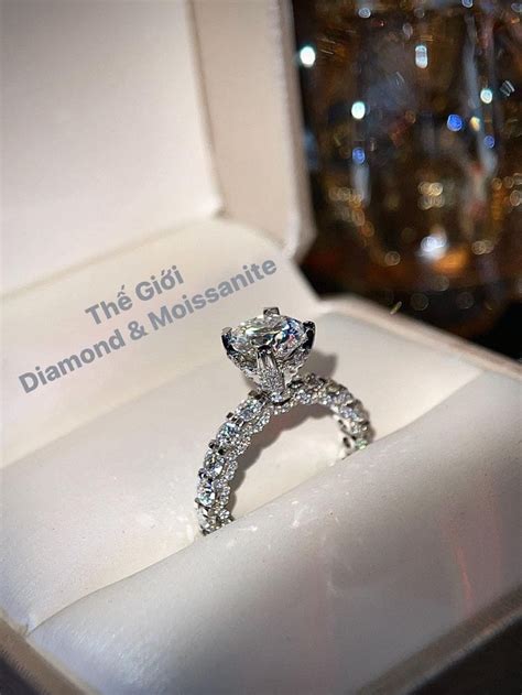 A Diamond Ring Sitting In A Box On Top Of A White Surface With The